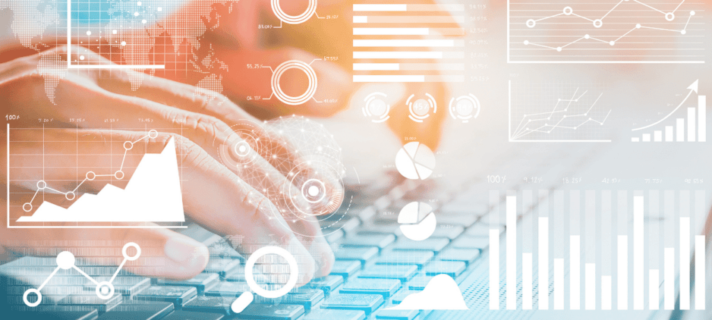 Grafy v popředí a za nimi v pozadí detail na ruce na klávesnici