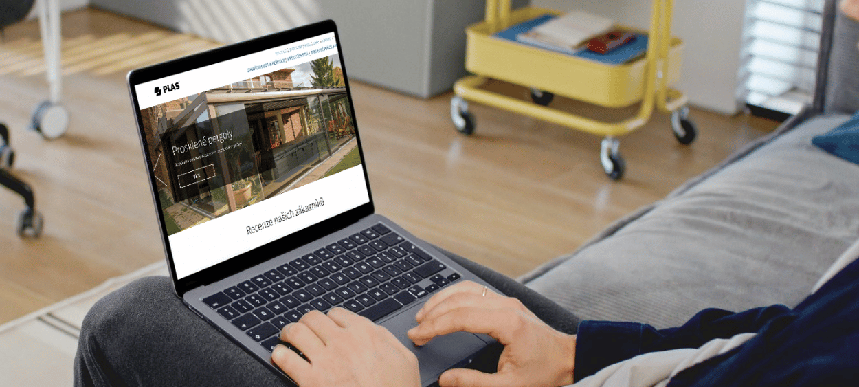 Plas na obrazovce nootebook. Ten notebook má někdo na klíně a sedí na gauči