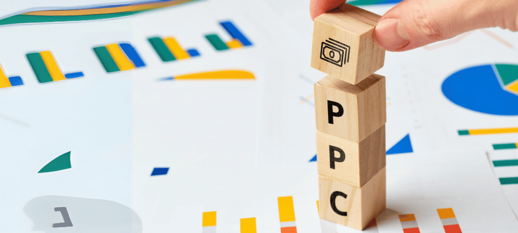 Na obrázku jsou kostičky na každé kkostičce je jedno písmeno, dohromady trvoří slovo ppc. V pozadí jsou papíry s diagramy