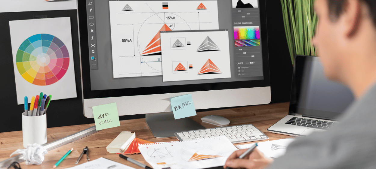 Navrhovaní grafiky - muž zezadu sedící u obrazovky na které má otevřený grafický program.